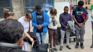 A diverse group of Olympic missionary volunteers pray together in Paris